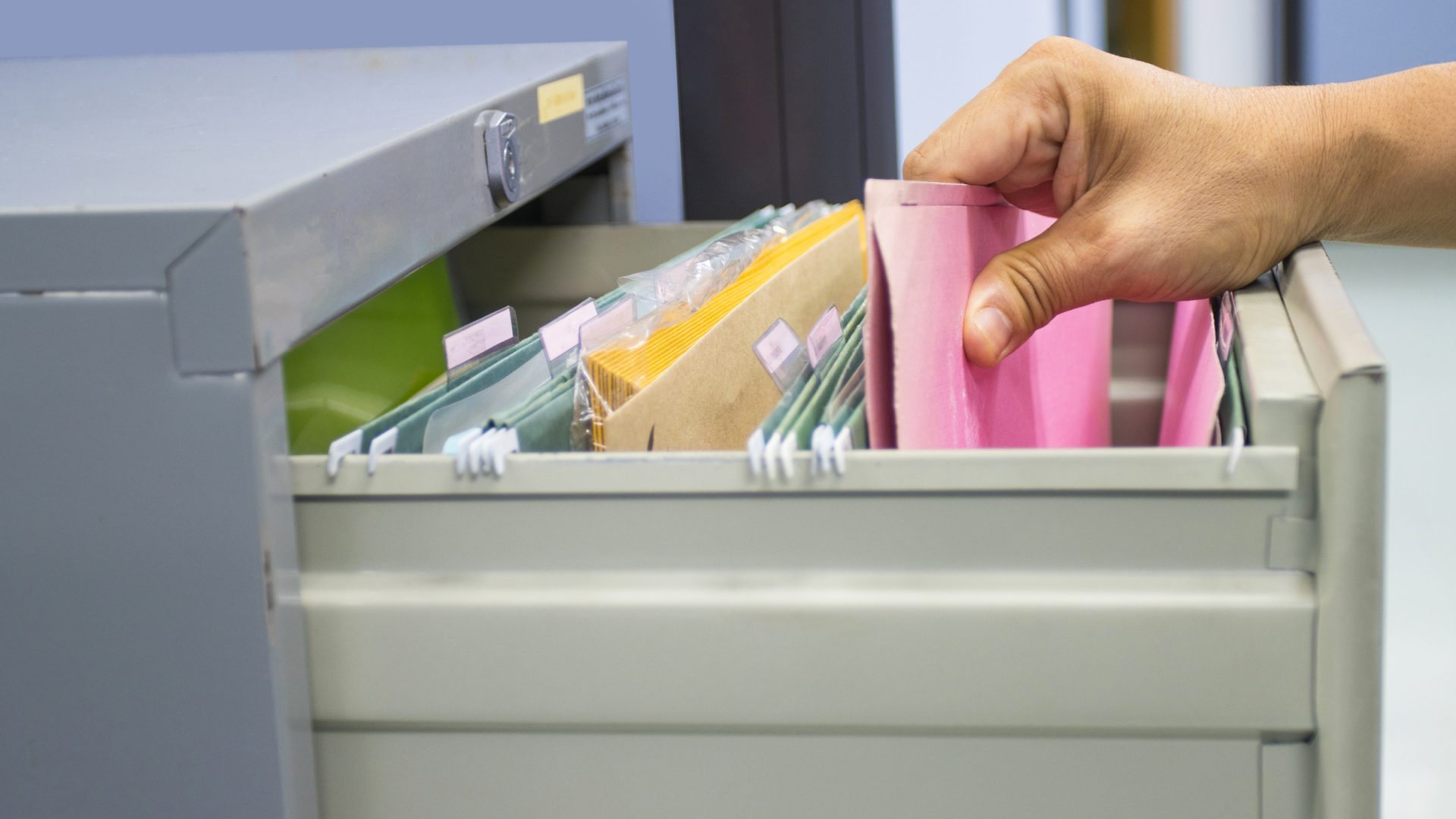 Hand of Man Search files document in a file cabinet in work office, concept business office life.